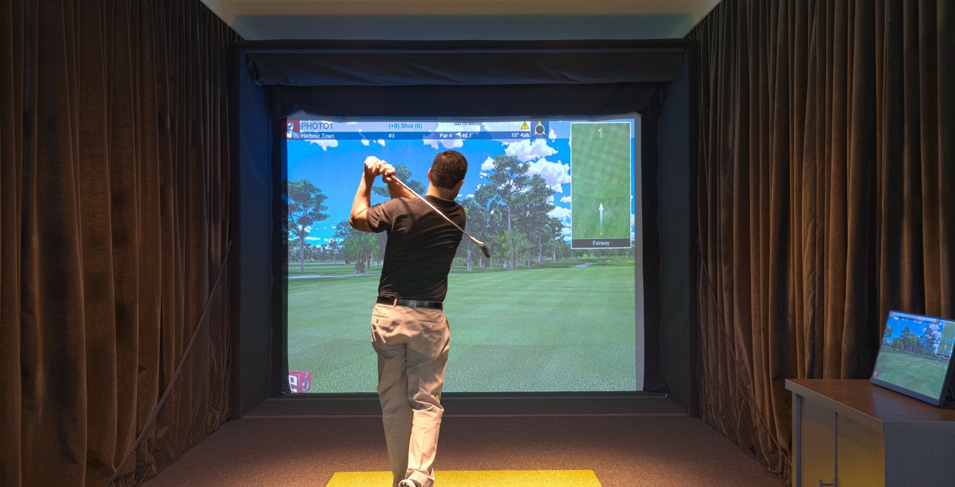 A guy using one of the golf simulators at 78Fitness