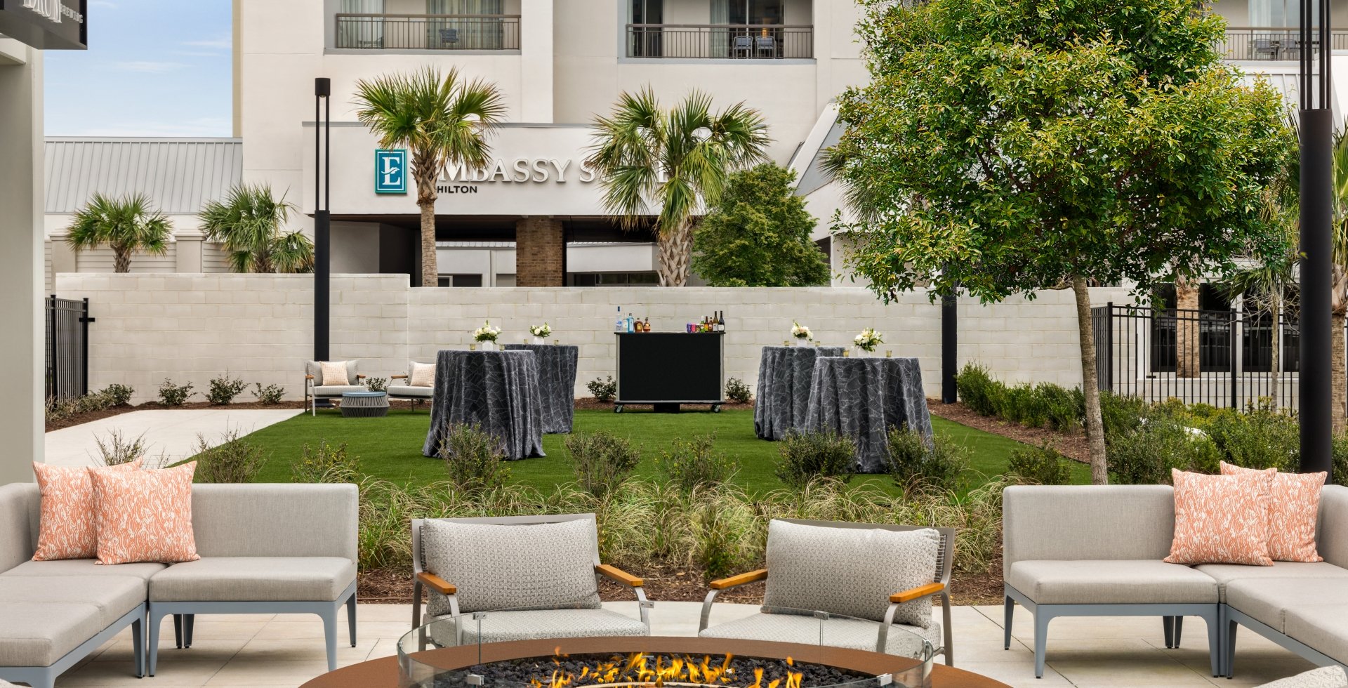 Currents Seaside Entertainment event lawn set up for a wedding cocktail reception and soft seating around a firepit