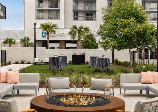 Currents Seaside Entertainment event lawn set up for a wedding cocktail reception and soft seating around a firepit