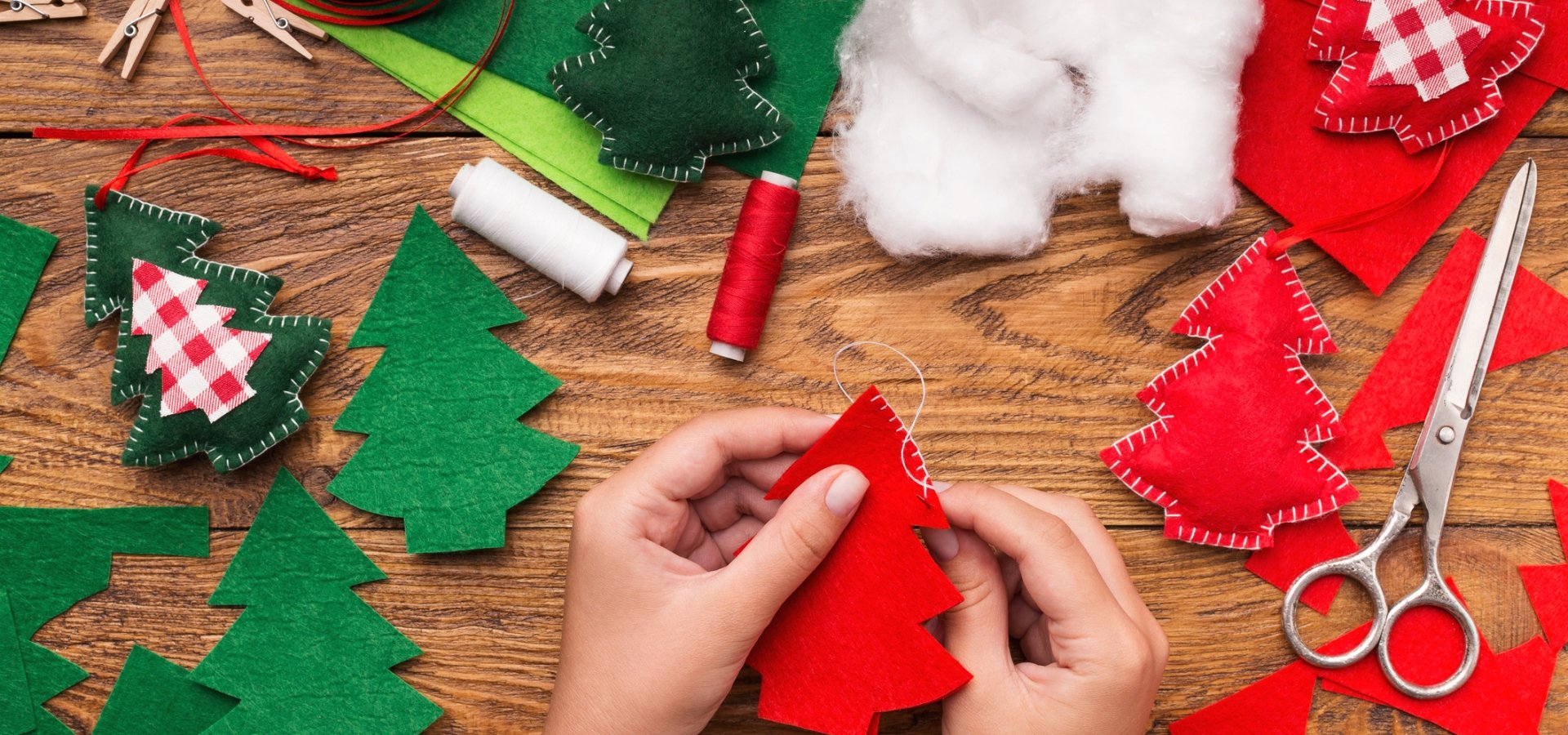 Someone hand crafting felt Christmas tree ornaments
