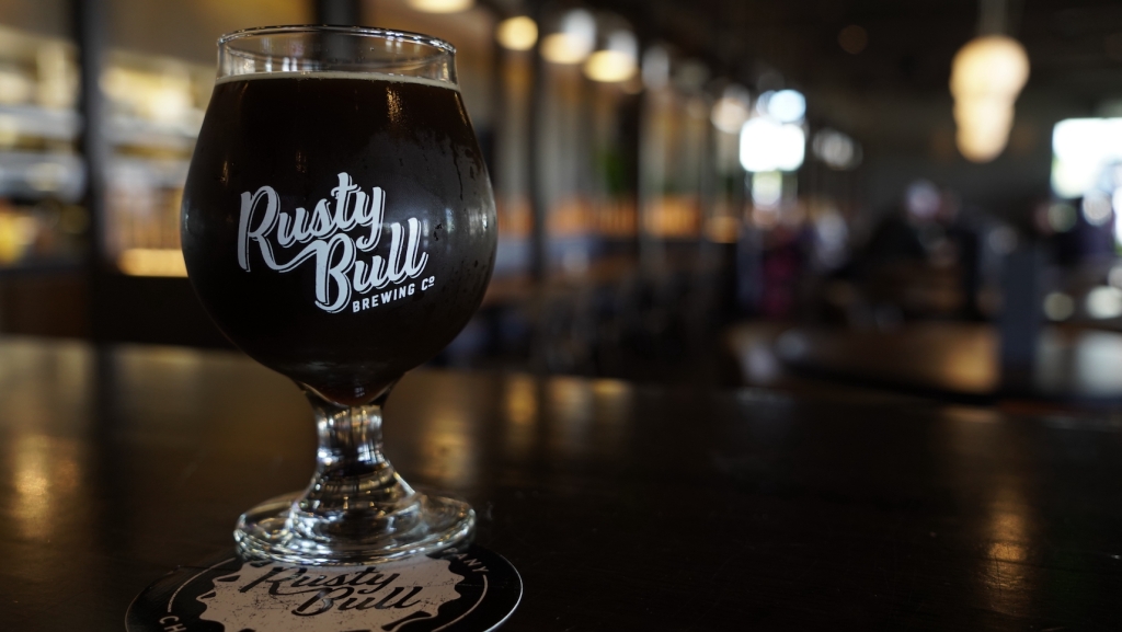 A glass of porter beer sits on a table.