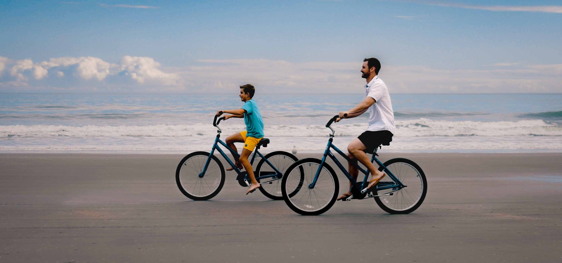 A father and Son biking on the beach