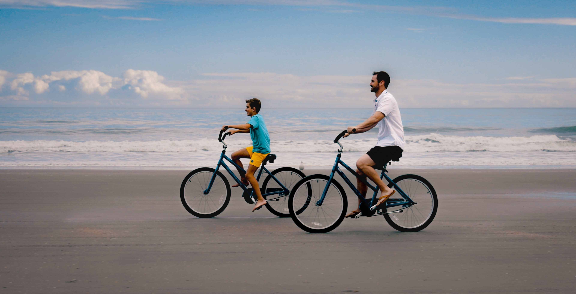 A father and Son biking on the beach