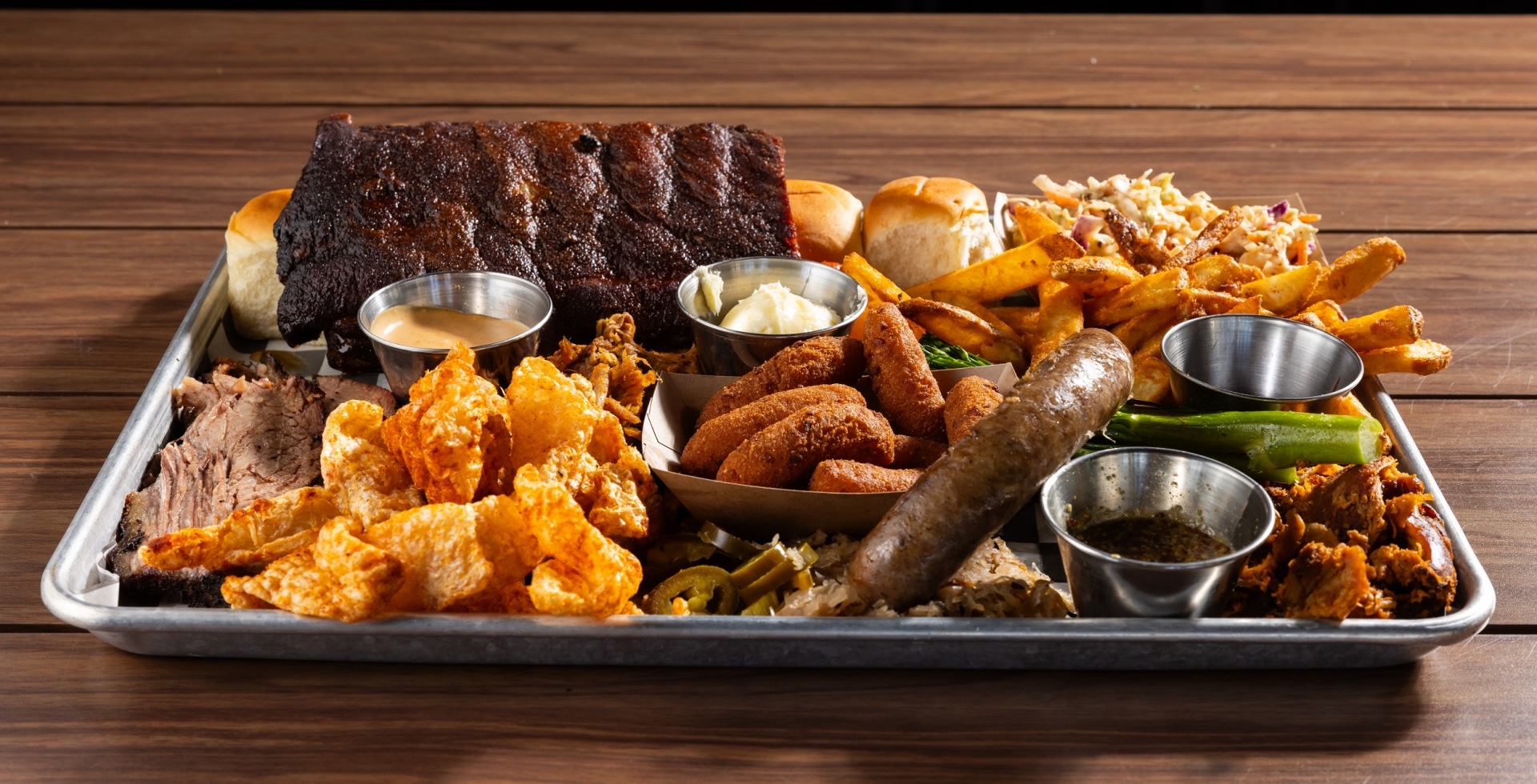 Black Drum Brewing Small BBQ Board consisting of 1/2 rack of ribs, sweet rolls, Cole slaw, French fries, broccolini, pulled chicken, pulled pork, brisket, pork skins, bratwurst, and hush puppies