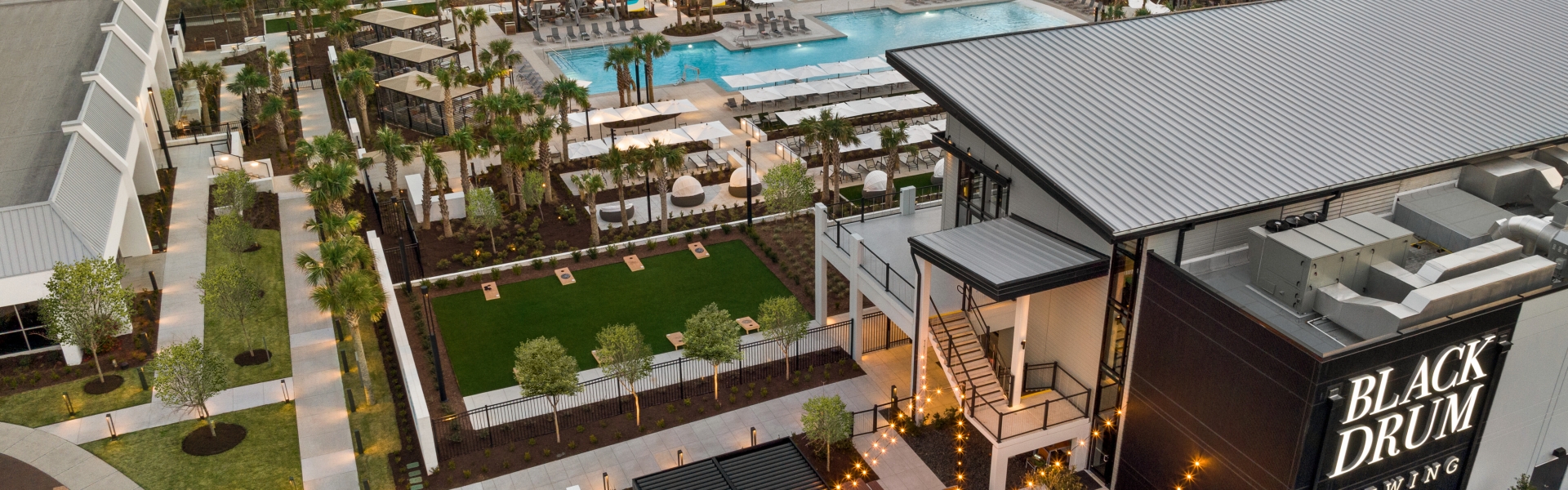 An aerial shot of a restaurant, pool, and beach in the background.