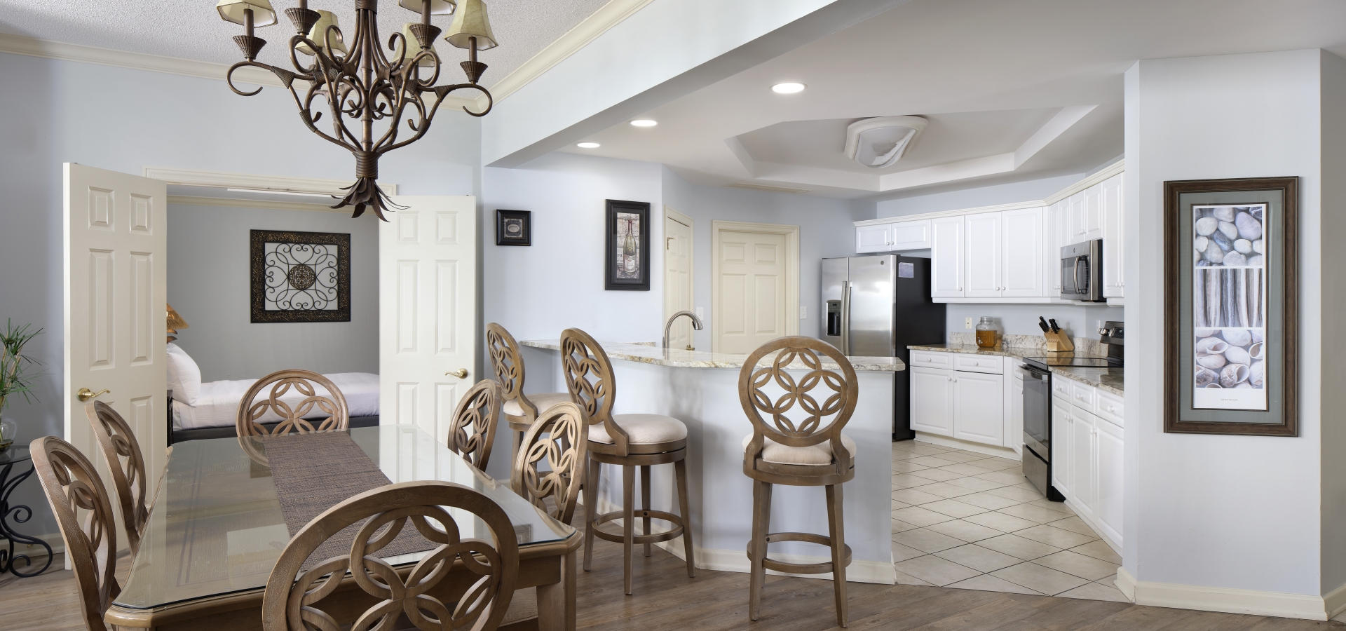 Margate condo dining area looking towards the kitchen, breakfast bar, and a bedroom