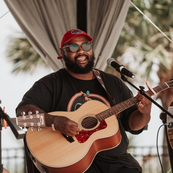Male live musician on stage with his guitar