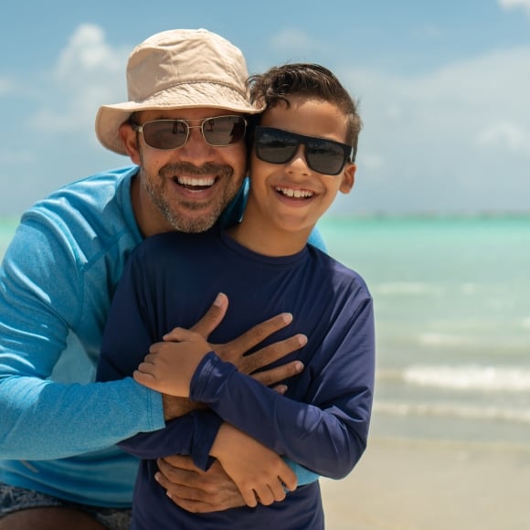 Dad hugging son on the beach