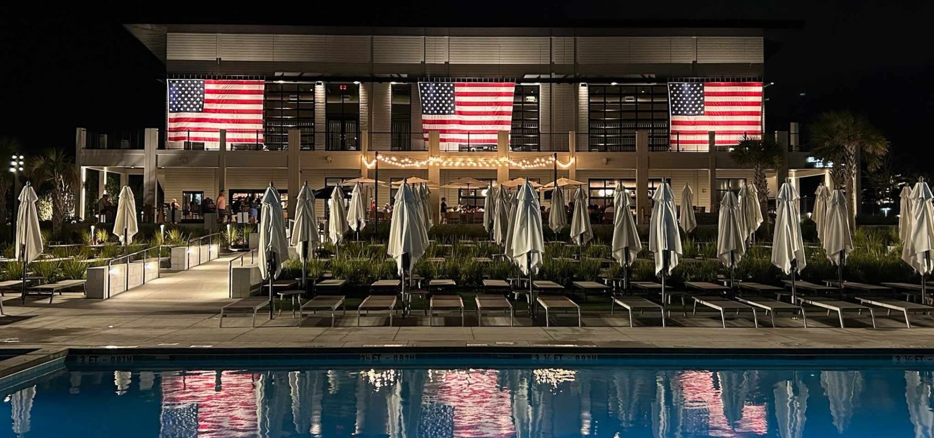 Black Drum Brewing at night with three American flags hanging for 4th of July